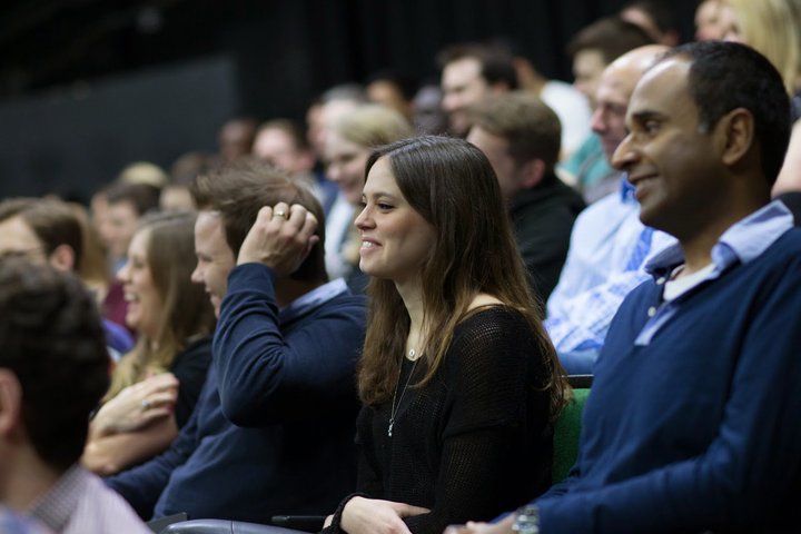 © J Tucker RADA Business course participants watch a presentation in an auditorium.