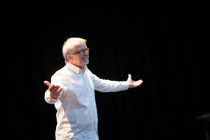A RADA Business tutor is standing and presenting a speech in a theatre.