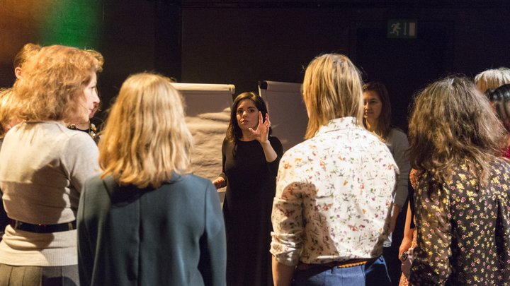A RADA Business tutor is standing and presenting a speech in a theatre.