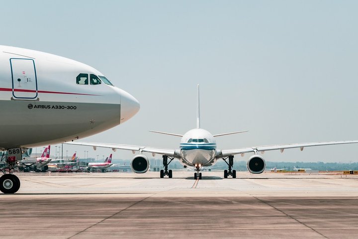 Two airplanes taxiing on a runway