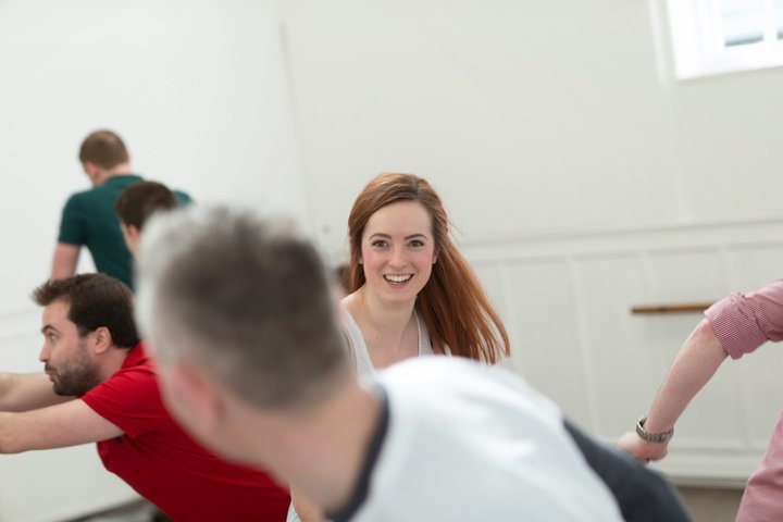 © J Tucker RADA Business participants smile and move around in a movement workshop.